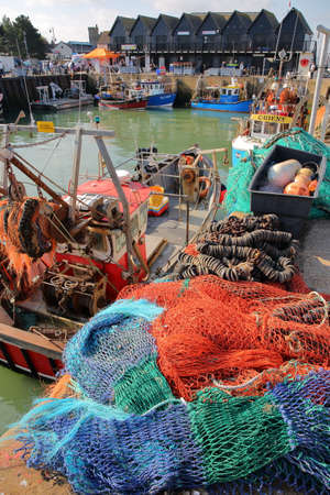 WHITSTABLE, UK - OCTOBER 15, 2017: The fishing Harbor with colorful fishing nets in the foreground and wooden huts in the backgroundのeditorial素材