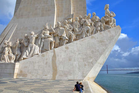 LISBON, PORTUGAL - NOVEMBER 3, 2017: A tourist couple watching the Monument of the Discoveries (Padrao dos Descobrimentos) located in Belem neighborhood beside the Tagus riverのeditorial素材