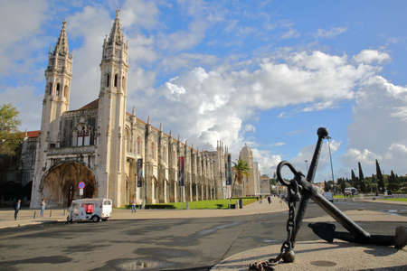 LISBON, PORTUGAL - NOVEMBER 3, 2017: Exterior facade of Jeronimos Monastery and Maritime Museum entrance in Belem neighborhood with a ship anchor in the foreground and a Tuk Tuk on the left sideのeditorial素材
