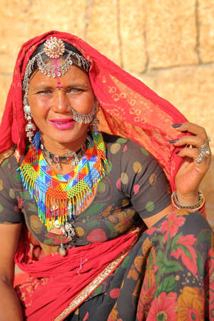 JAISALMER, RAJASTHAN, INDIA - DECEMBER 21, 2017: Portrait of a beautiful woman with clear eyes and dressed with traditional colorful sari and jewels at the entrance of Jaisalmer Fortのeditorial素材