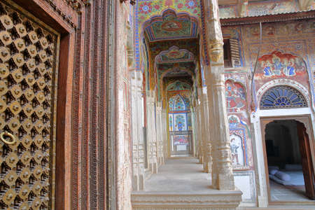 NAWALGARH, RAJASTHAN, INDIA - DECEMBER 25, 2017: Bhagat Haveli with colorful frescoes and paintings and a wooden door in the foregroundのeditorial素材