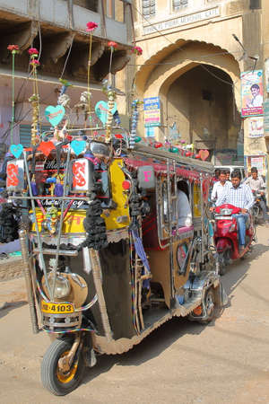 NAWALGARH, RAJASTHAN, INDIA - DECEMBER 28, 2017: A colorful and decorated Tuk Tuk with an entry gate...