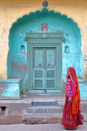 NAWALGARH, RAJASTHAN, INDIA - DECEMBER 26, 2017: The main entrance to a haveli Home with a woman...