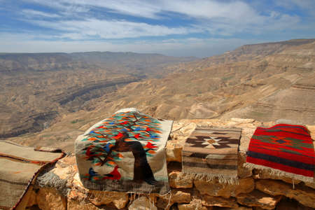 Wadi Mujib Canyon viewed from Kings Road with local carpets souvenirs in the foreground, Jordan, Middle Eastの写真素材