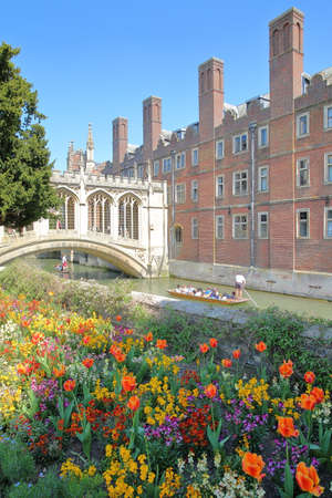 CAMBRIDGE, UK - MAY 6, 2018: The Bridge of Sighs at St John's College University with tourists and students punting on the river Cam with colorful flowers in the foregroundのeditorial素材