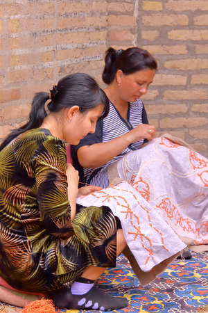 KHIVA, UZBEKISTAN - MAY 2, 2011: Traditional embroidery with two young women traditionally dressedのeditorial素材