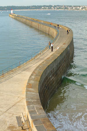 SAINT MALO, FRANCE - AUGUST 31, 2018: View of the pier (Mole des Noires) from the ramparts, with the lighthouse and the town of Dinard in the backgroundのeditorial素材