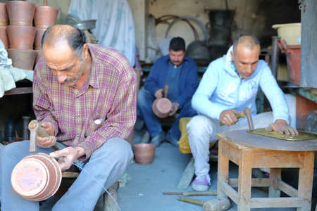 KAIROUAN, TUNISIA - DECEMBER 10, 2019: Brass and copper craftsmen at work (El Moez Ibn Badis avenue)のeditorial素材