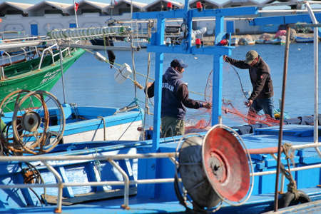 MAHDIA, TUNISIA - DECEMBER 26, 2019: Fishermen preparing their net at the fishing portのeditorial素材