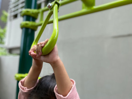 close up hand of girl hanging at playground.close up hands of girl playing on playground, hanging walk along the monkey bars.の写真素材