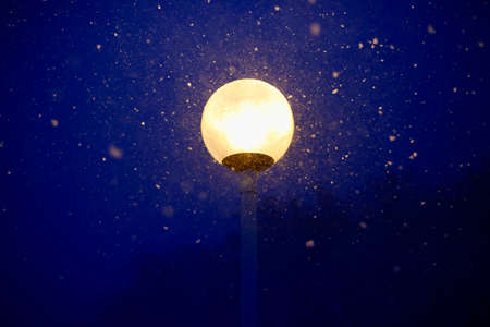 A street lamp in a snowstorm on Otaru's Otengo Mountain under a quiet blue night sky