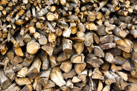Stack of roughly cut small firewood logs in a pile