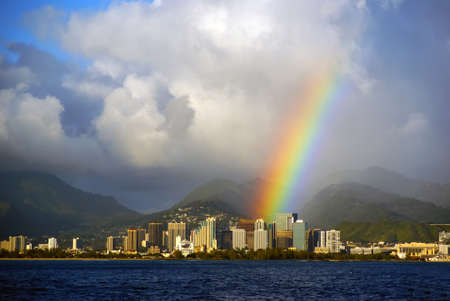 Honolulu Hawaii with a bright rainbow after a rain stom seen from the open ocean on Oahu islandの写真素材