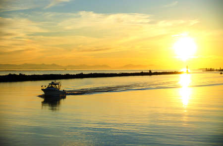 Sunset on Steveston Village marina with Vancouver Island mountains in the background, Vancouver, British Columbiaの写真素材