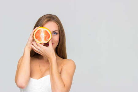 Beautiful sexy girl with grapefruit isolatedの写真素材