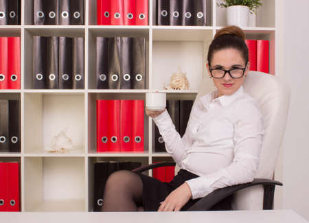 Business woman sitting with cup of coffeeの写真素材