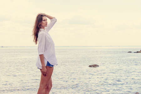 Beautiful woman posing near the beachの写真素材