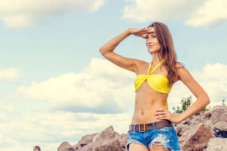 Beautiful woman in bikini posing near on the beachの写真素材