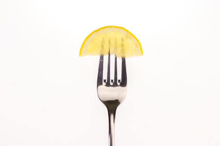 lemon slice on a fork on a white backgroundの写真素材