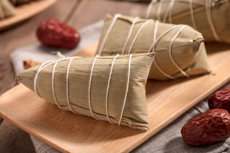Traditional Chinese Food, Zongzi or Sticky Rice Dumpings on Wood Table Surface.の写真素材
