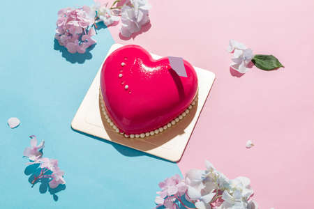Heart-shape Mousse Cake on Red and Blue Background with Hydrangea.