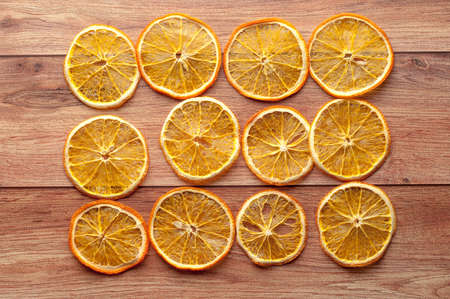 Healthy snack. Homemade dehydrated orange chips on a rustic wooden backgroundの写真素材