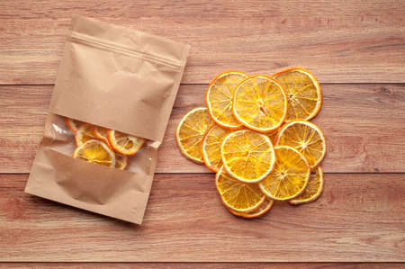 Healthy snack. Homemade dehydrated orange chips on a rustic wooden backgroundの写真素材