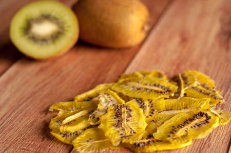 Healthy snack. Homemade dehydrated kiwi chips and fresh apples on a rustic wooden backgroundの写真素材