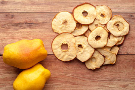 Healthy snack. Homemade dehydrated pear chips on rustic wooden backgroundの写真素材