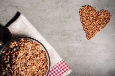 boiled buckwheat porridge in a transparent plate on a gray background.の写真素材