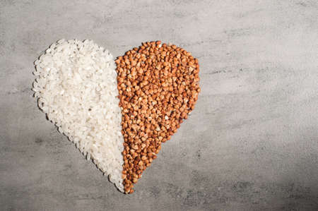 heart of rice groats and heart of buckwheat on a gray background.Copy spaceの写真素材