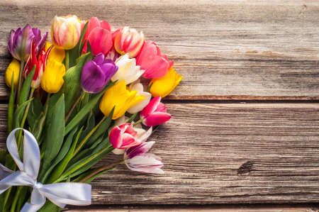 Bright spring bouquet of colorful tulips on wooden backgroundの写真素材