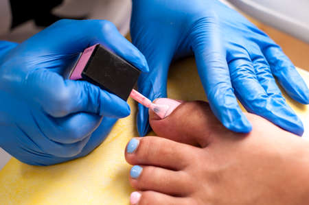 Salon pedicure procedure in process. Professional works in gloves for sterilityの写真素材