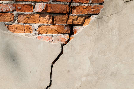 Old brick wall with fallen off plaster. Background of crack brick wall textureの写真素材