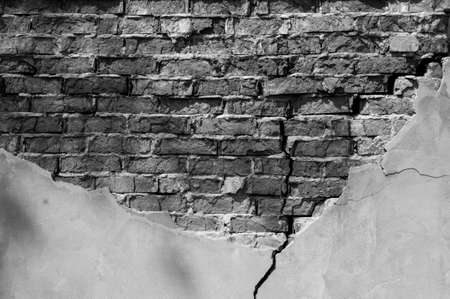 Old brick wall with fallen off plaster. Background of crack brick wall textureの写真素材