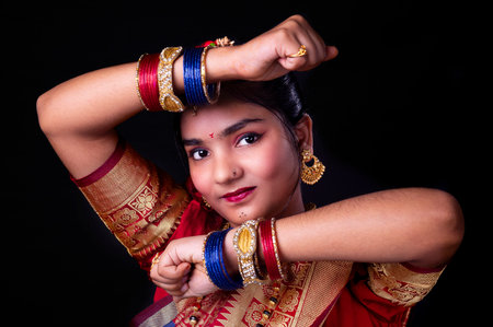 Portrait of a beautiful Indian woman wearing traditional clothing on black backgroundの写真素材