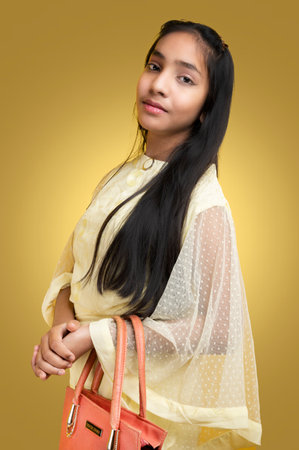 Portrait of a beautiful young asian girl on yellow background.の写真素材