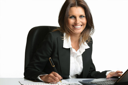 Beautiful business woman smiles working at computer . White backdropの写真素材