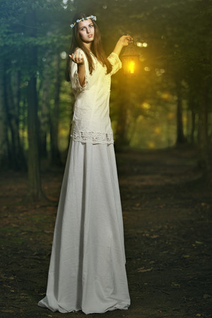 Fairy beautiful woman in magical forest . Fantasy and surreal conceptの写真素材