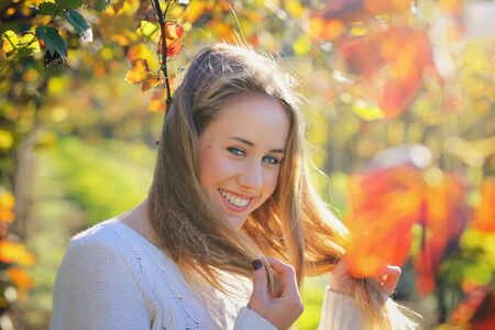 Beautiful smile from young woman . Autumn portrait outdoorの写真素材
