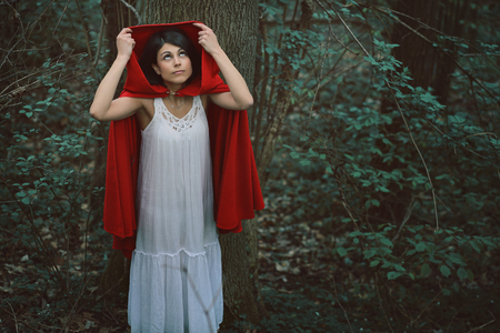 Little red riding hood alone in dark forest before the storm . Fantasy and fairy taleの写真素材
