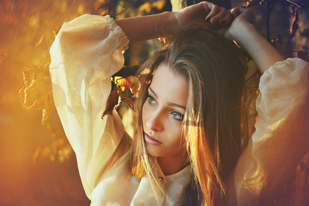 Autumn sunset light portrait of a beautiful woman . Seasonal colorsの写真素材