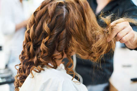 Barber designing good hairstyle of beautiful lady model in the saloonの写真素材