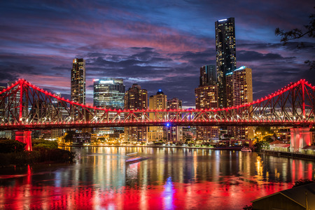 Pink sunset behind the red lights of the Storey Bridge against the Brisbane city skylineのeditorial素材