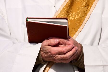 Folded hands of a priest の写真素材