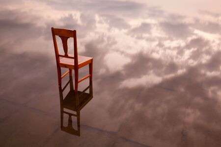 The old chair in the lake at sunsetの写真素材