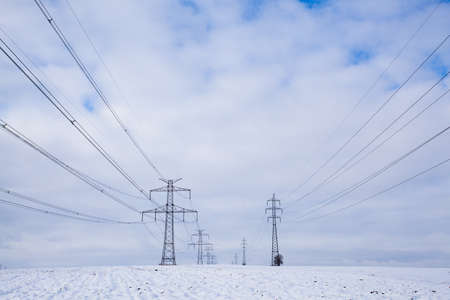 Transmission towers on the field in winterの写真素材