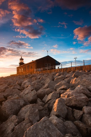 Lighthouse on the pier - Scenic view of rocky sea defences, Morecambe, Lancashire, England,の写真素材