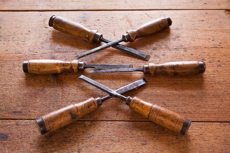 Old wooden chisels on the wood tableの写真素材