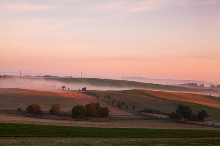 The fallow fields in autumn in the mist at sunrise 